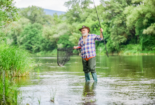 Mature man fishing. Retired fisherman. Fisherman with fishing rod. Activity and hobby. Fishing freshwater lake pond river. Male leisure. Happiness is rod in your hand. Senior man catching fish