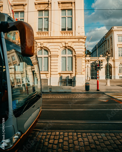 Street with passing tram and adjacent white buildings