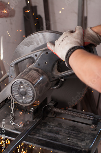 Cutting metal with grinder in workshop. Sparks while grinding iron. Cutting machine.