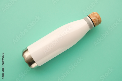 Reusable eco friendly sustainable water bottle on mint background.