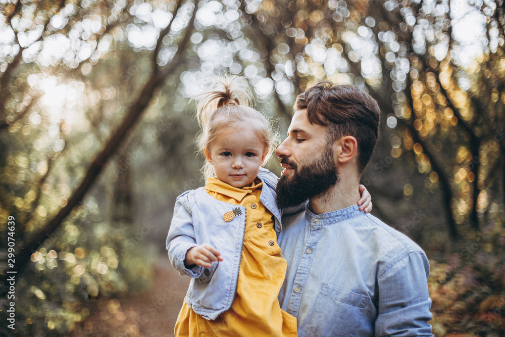 happy father and daughter playing while walking in a beautiful autumn park. Ideal weekend father with his little daughter. selective focus, noise effect