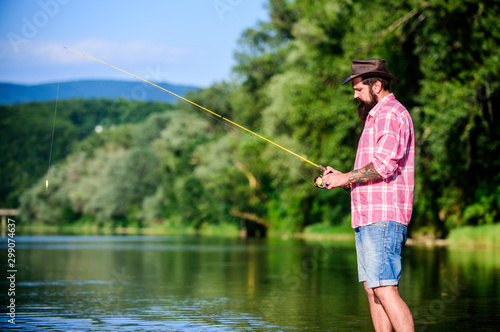 weekend relax. mature bearded man with fish on rod. hipster fishing with spoon-bait. fly fish hobby. Summer fishery activity. successful fisherman in lake water. big game fishing. relax on nature