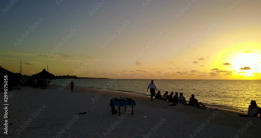 Young people sitting on beach, watching amazing sunset with incredible yellow colors in Caribbean island Young people sitting on beach, watching amazing sunset with incredible yellow colors in Caribbean island