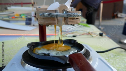  Rube Goldberg Machine. A broken egg flows into a heated pan. photo