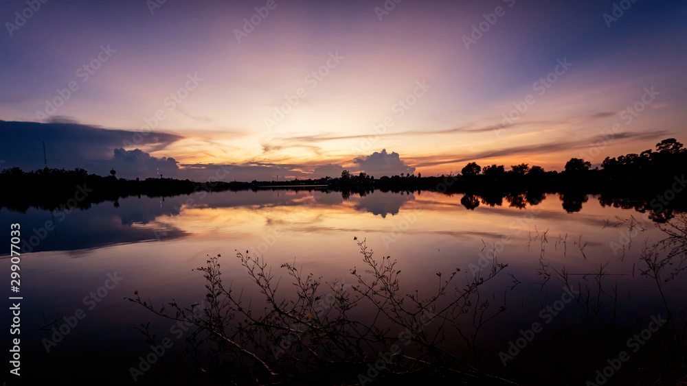 Obraz premium Beautiful sunset sky with reflection on the lake