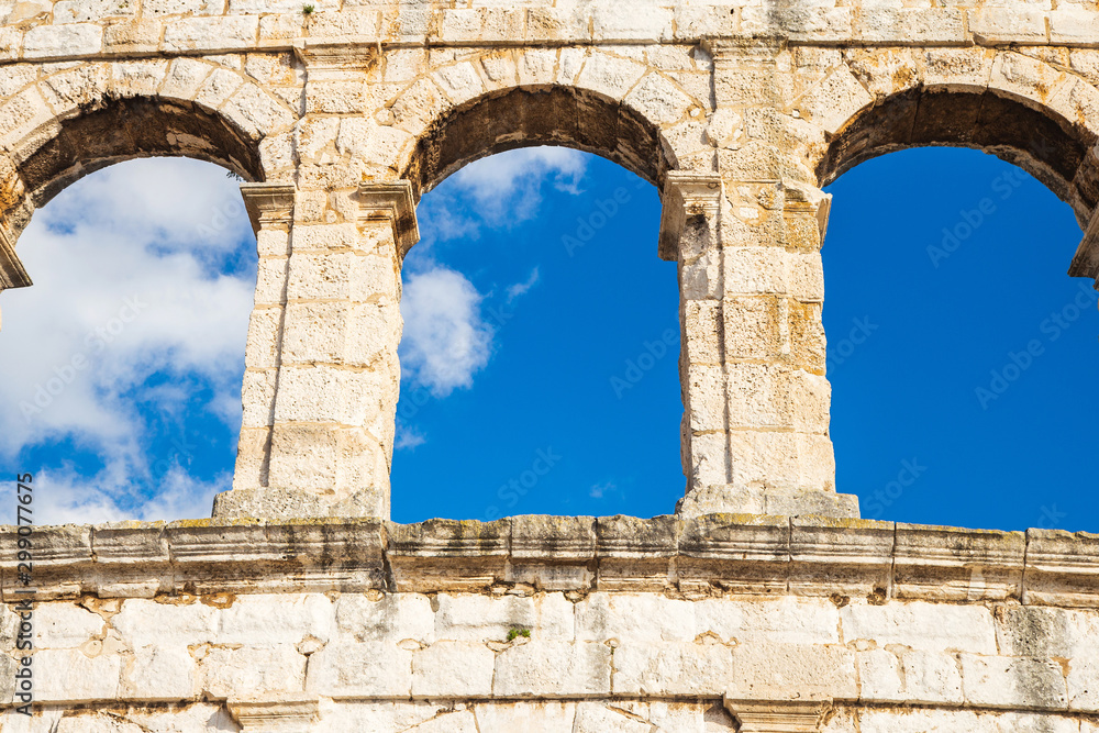 Ancient Roman Arena in Pula, Istria, Croatia, historic amphitheater wide view of high walls on blue sky background