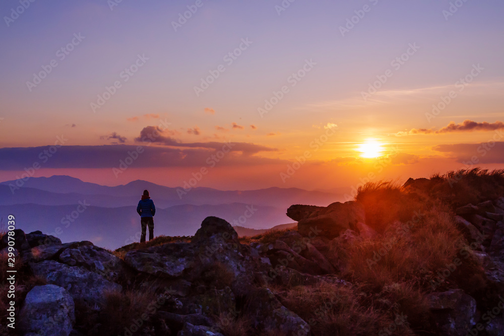 Tourist watching sunset in the mountains