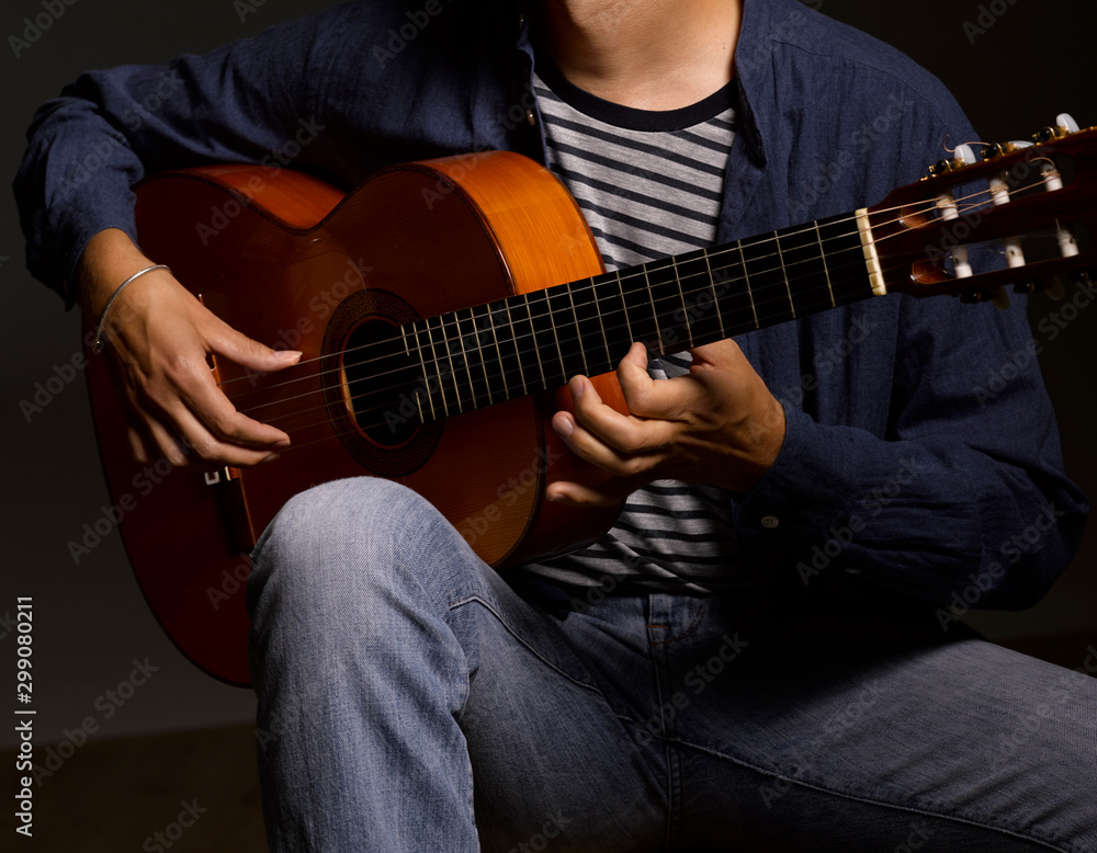 Obraz premium Músico tocando guitarra en ambiente oscuro