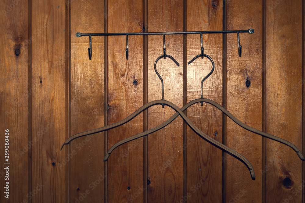 Fototapeta premium Hangers on wooden wall background. dress rack