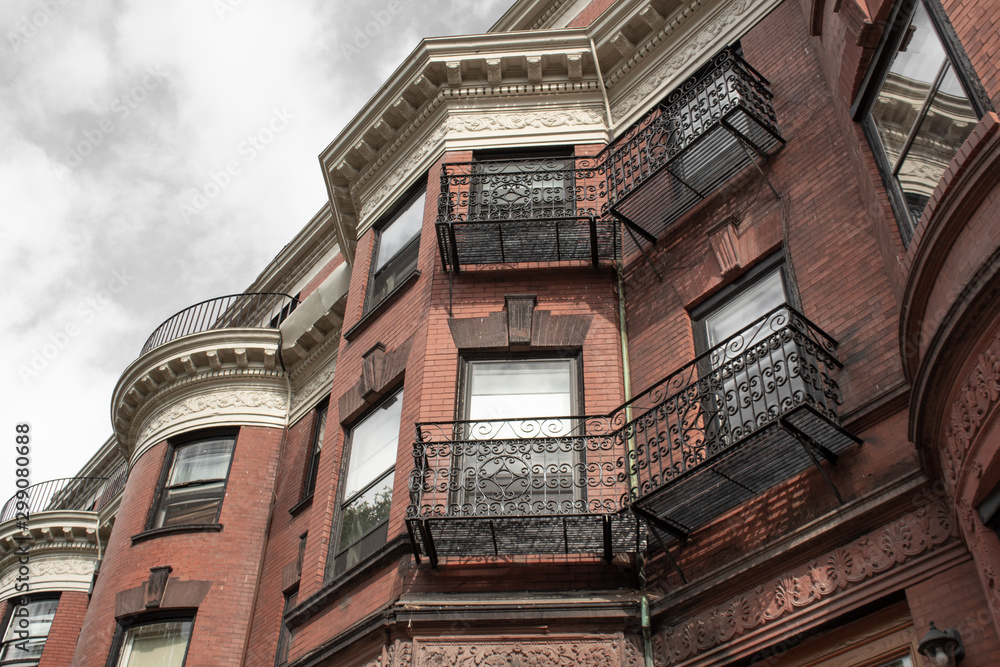 Obraz premium Elaborate wrought iron railings and frieze details on the face of old brownstones, horizontal aspect
