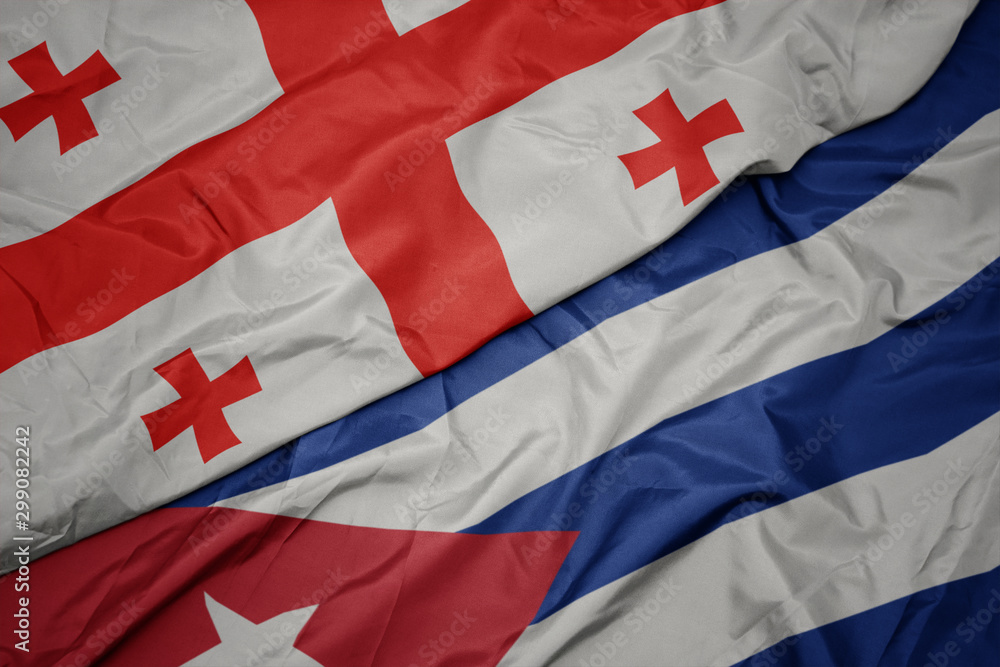 Fototapeta premium waving colorful flag of cuba and national flag of georgia.