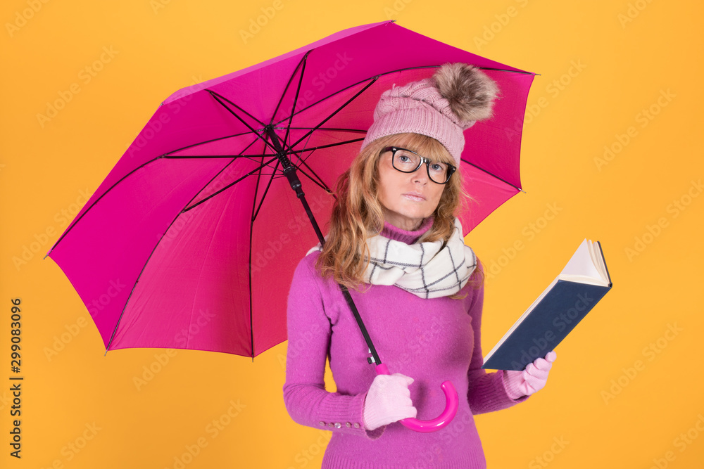 Fototapeta premium adult woman with umbrella and book warm clothes