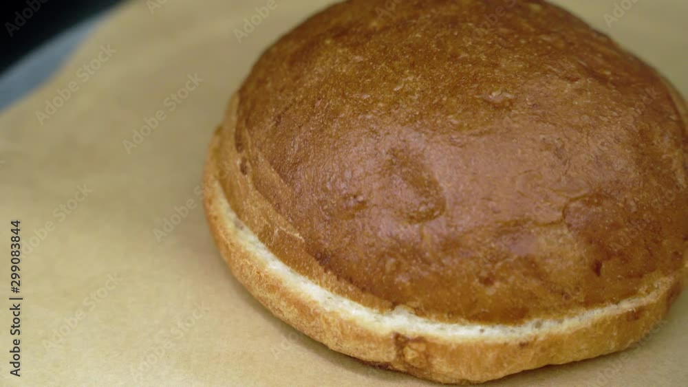 Close - up of fresh burger bun served on pieces of brown paper Close - up of fresh burger bun served on pieces of brown paper