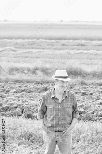Black and white photo of Senior farmer standing in field