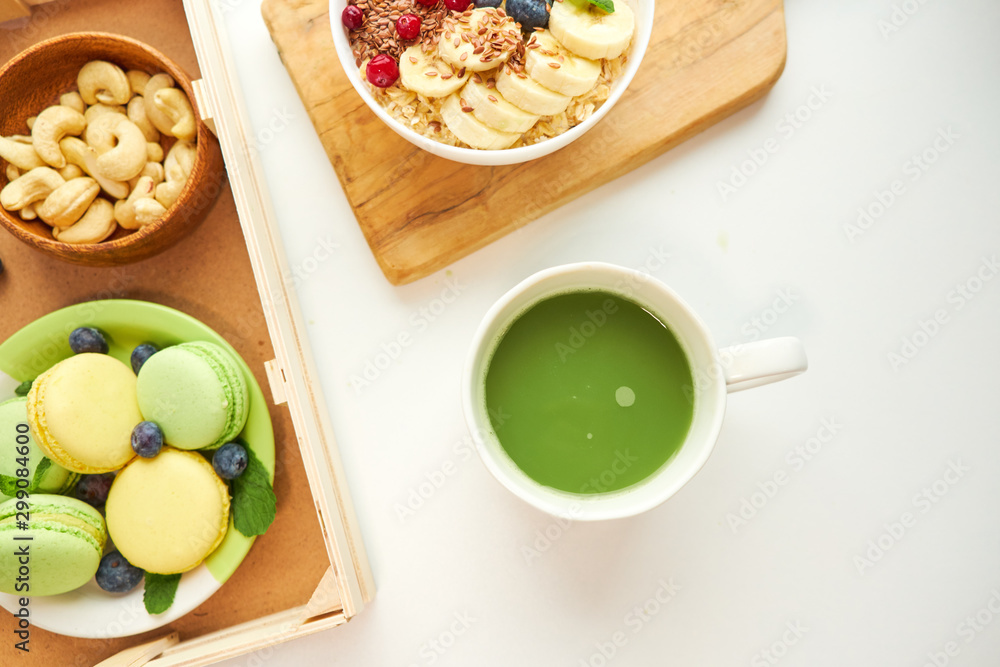 matcha green tea, breakfast top view white background. oatmeal with berries, toasts on a wooden tray, nuts, coffee matcha green tea, breakfast top view white background. oatmeal with berries, toasts on a wooden tray, nuts, coffee
