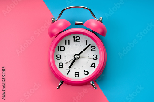 pink rustic alarm clock on pink blue background