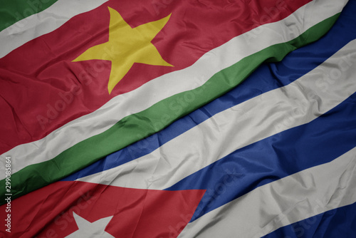 waving colorful flag of cuba and national flag of suriname.