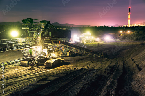 Heavy industrial machine in coal mine with power plant chimney in the night © davidjancik