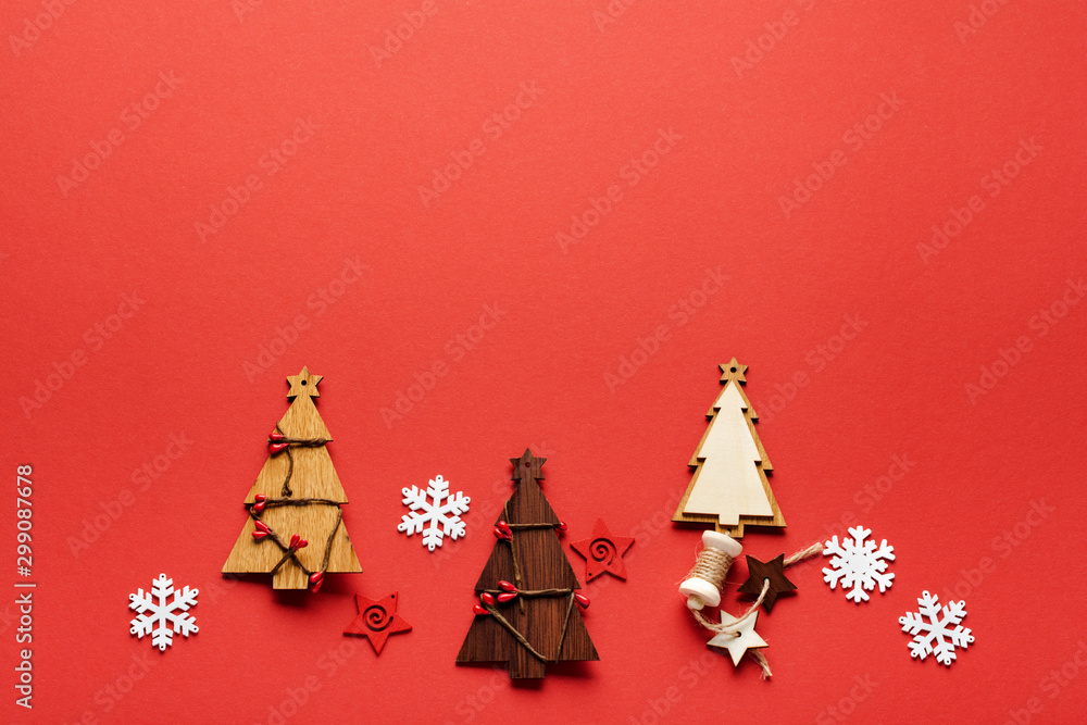 Christmas pattern made of Wooden Christmas fir tree toys, snowflakes and stars on red background. Flat lay, top view. New year concept. Top view, minimal christmas style and holiday concept. Christmas pattern made of Wooden Christmas fir tree toys, snowflakes and stars on red background. Flat lay, top view. New year concept. Top view, minimal christmas style and holiday concept.
