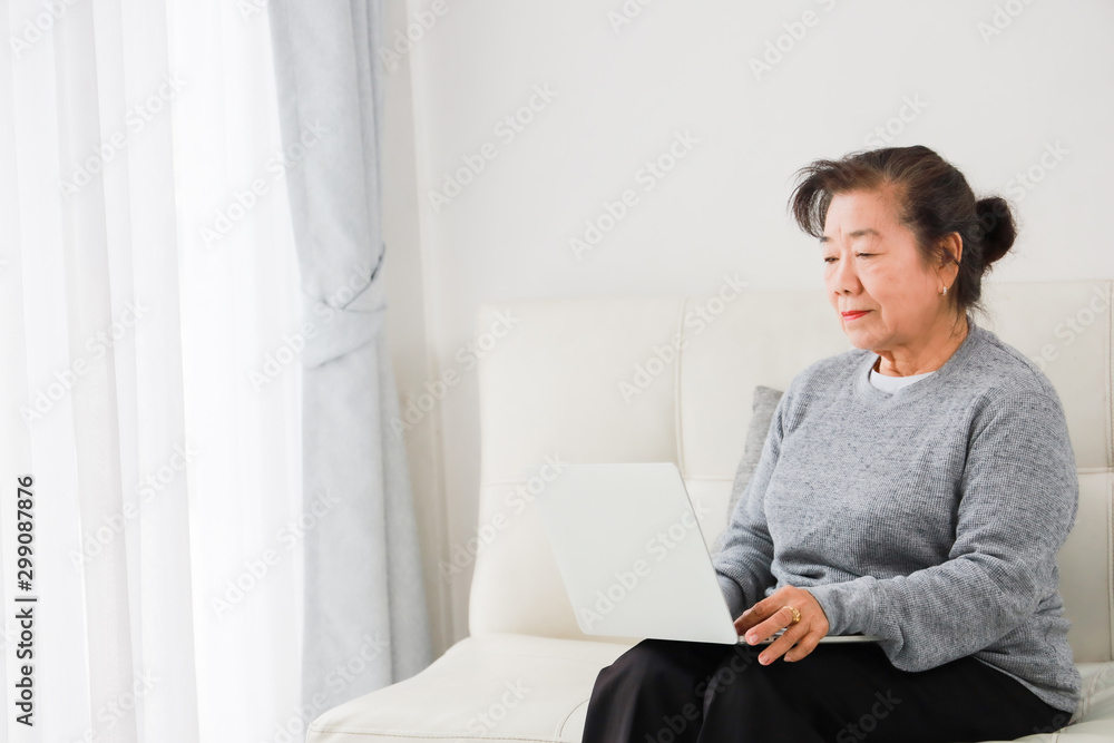 Asian senior woman mother talking with mobile phone and drinking coffee in living room Asian senior woman mother talking with mobile phone and drinking coffee in living room