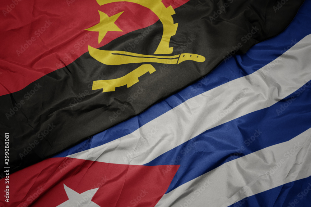Fototapeta premium waving colorful flag of cuba and national flag of angola.