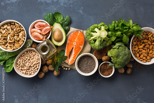 Health food fitness. Food sources of omega 3 and omega 6 on dark background top view. Foods high in fatty acids including vegetables, seafood, nut and seeds