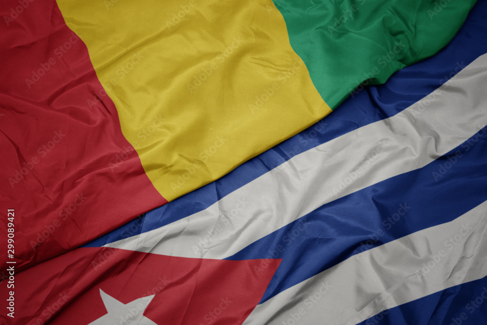 waving colorful flag of cuba and national flag of guinea.
