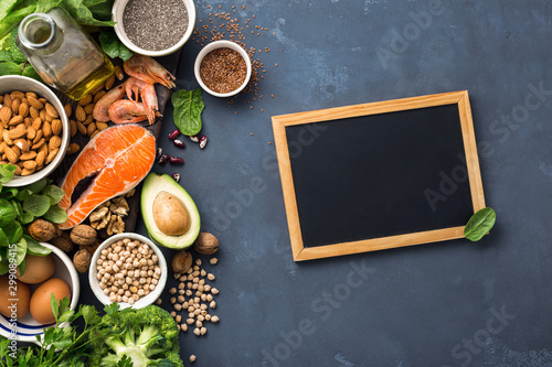 Fototapeta Naklejka Na Ścianę i Meble -  Empty chalkboard for your text with Food sources of omega 3 and healthy fats. Foods high in fatty acids including vegetables, seafood, nut and seeds