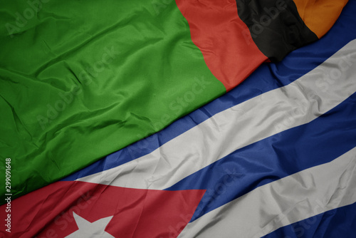 waving colorful flag of cuba and national flag of zambia.