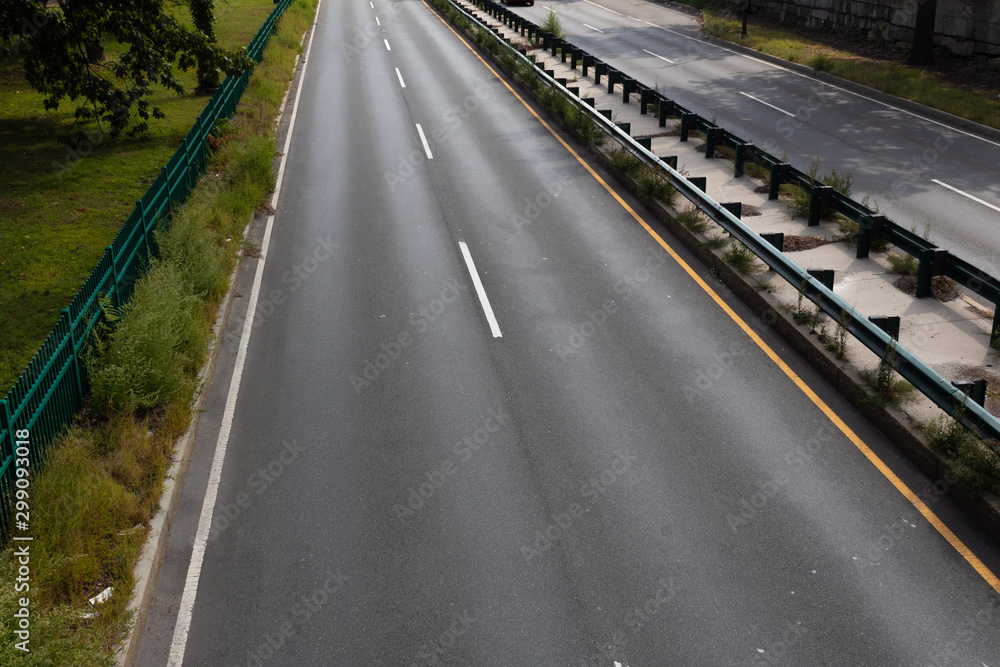 Divided urban highway, overhead view with concrete and guardrail median, horizontal aspect
