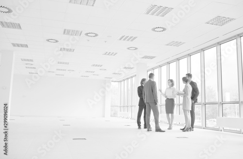 Businessman discussing with colleagues against window in new office during meeting