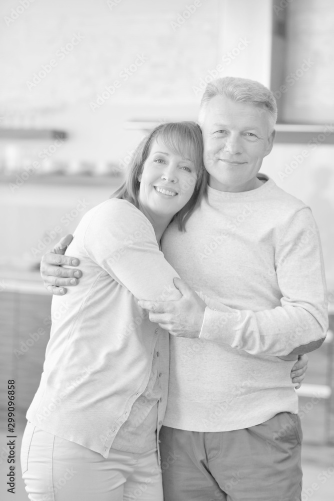 Portrait of mature couple embracing while standing at home Portrait of mature couple embracing while standing at home