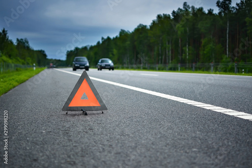 Warning triangle on a road in a green summer forest. Copy space