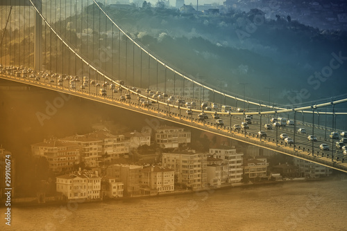 A bridge over the Bosphorus with many cars and houses on the shore. View from above. Istanbul. The human anthill of a big city.