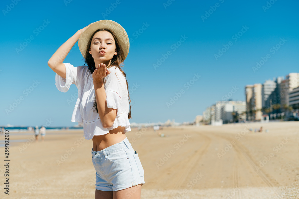 european woman blows a kiss on the beach