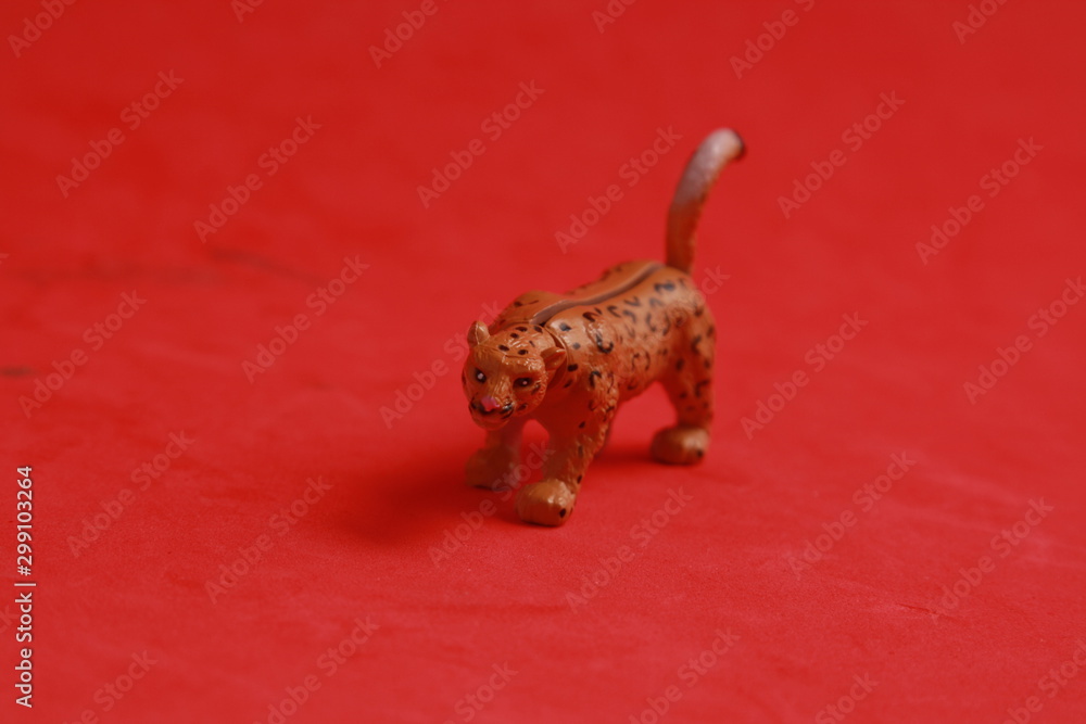Fototapeta premium plastic toy with leopard shape in color background