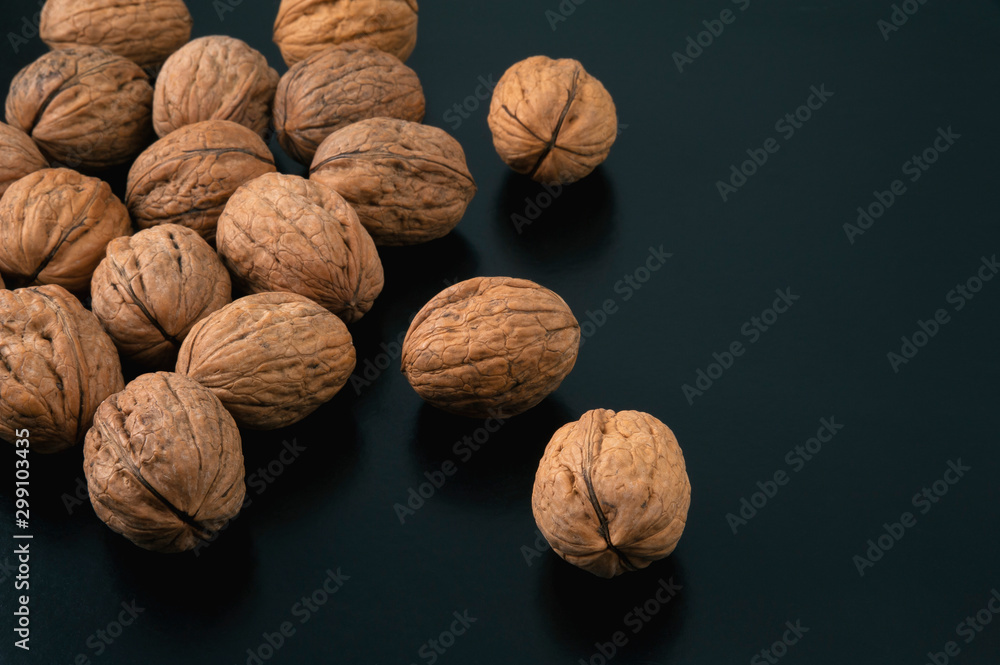 Pile of walnuts on black background. Side view. Pile of walnuts on black background. Side view.