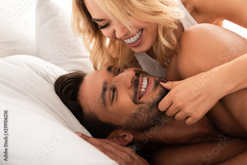 laughing woman hugging her happy boyfriend in bed in the morning
