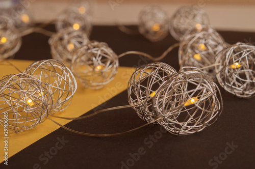 Splendid view of metallic spherical christmas decoration, lights. Beautiful combination of yellow and black backgrounds. Trendy concept