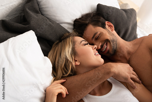 Εκτύπωση καμβά smiling tender couple hugging in bed in the morning