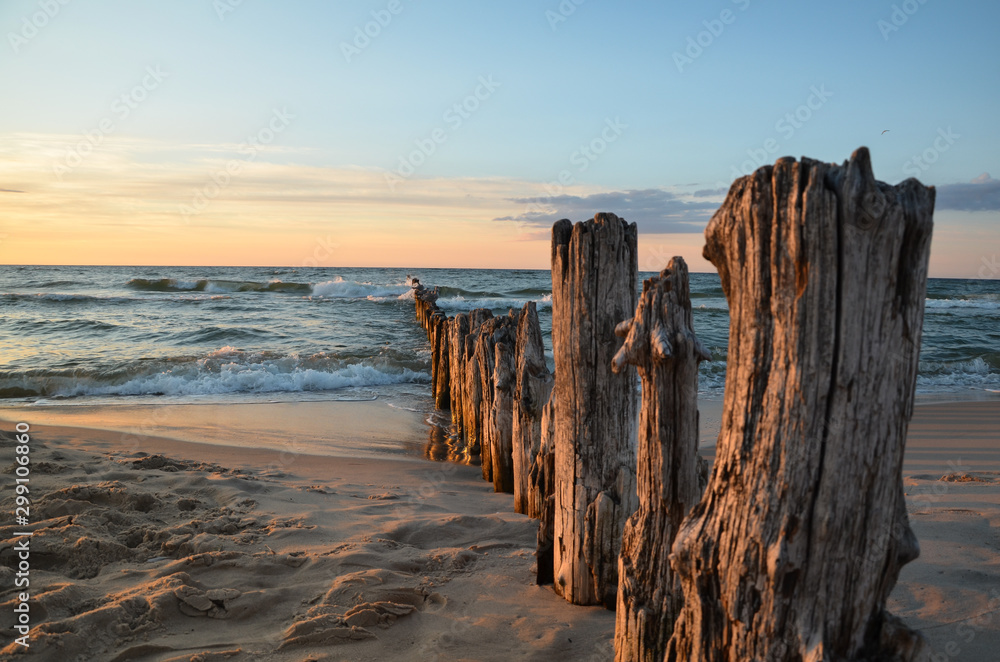 Wooden breakwater during sunset over the Baltic Sea, Unieście, Poland.