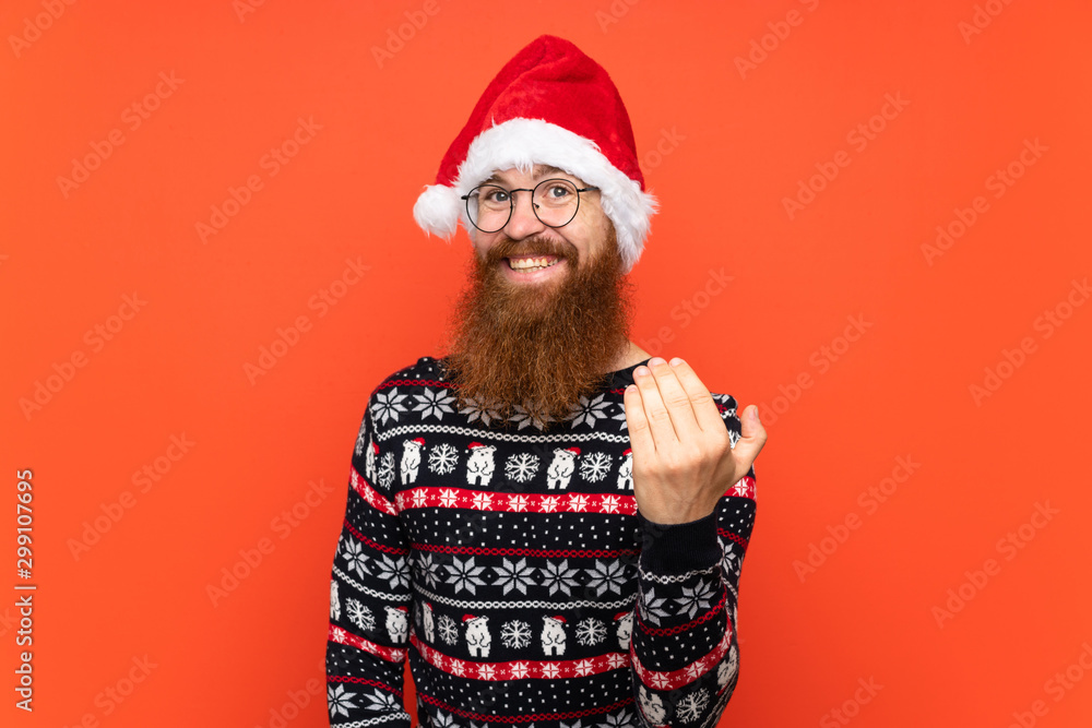 Christmas man with long beard over isolated red background inviting to come with hand. Happy that you came Christmas man with long beard over isolated red background inviting to come with hand. Happy that you came