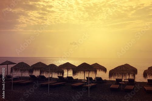 Sunrise in popular volcanic beach of Perissa with dark sandy seascape  Santorini island  Cyclades  Greece