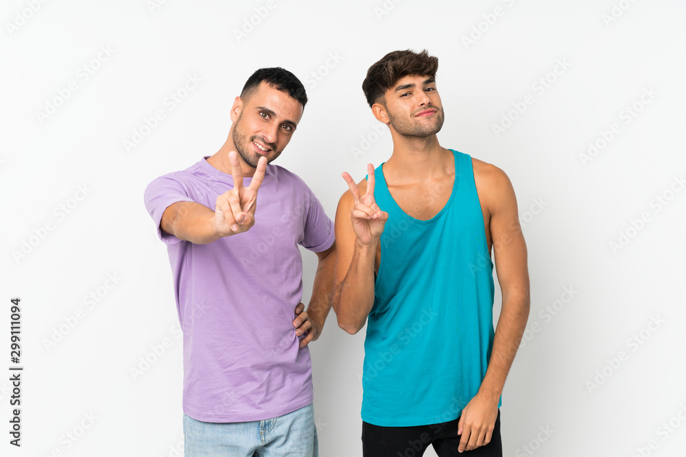 Two men over isolated background smiling and showing victory sign Two men over isolated background smiling and showing victory sign