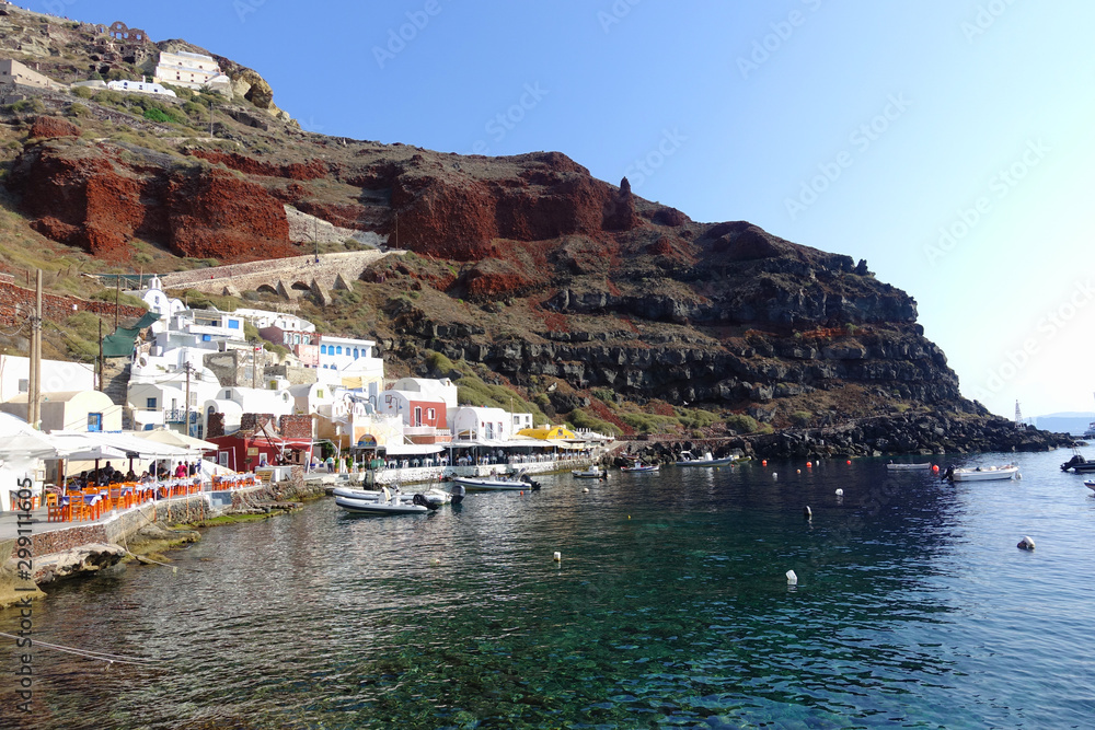 Photo from picturesque fishing harbour and bay of Ammoudi below iconic and famous village of Oia, Santorini island, Cyclades