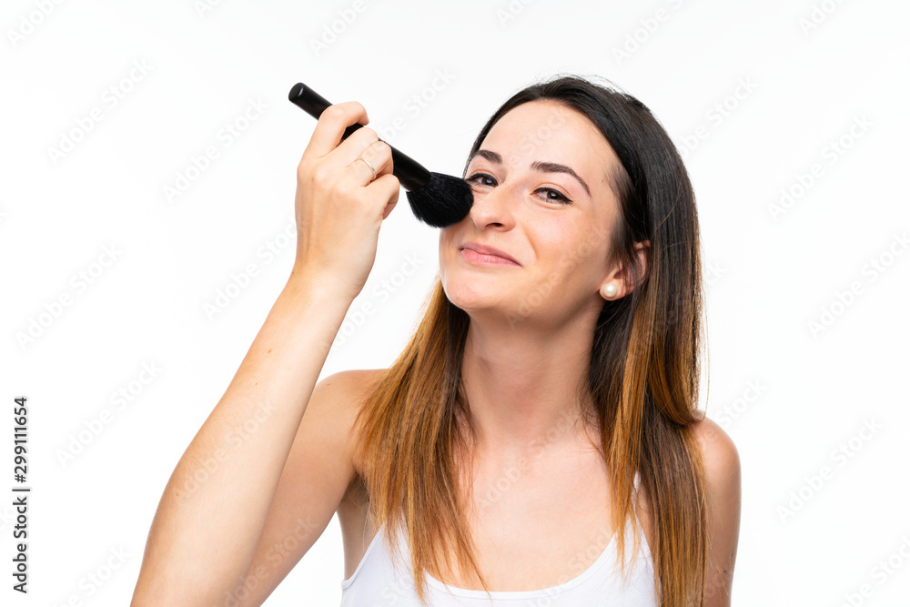 Young woman holding a lot of makeup brush over isolated white background Young woman holding a lot of makeup brush over isolated white background