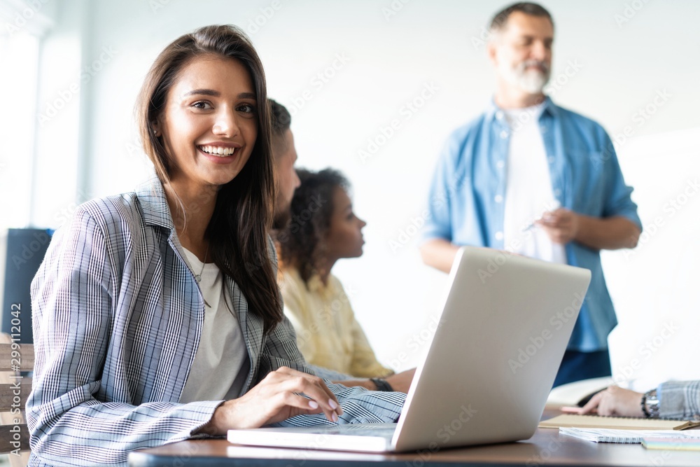 Beautiful business lady is looking at camera and smiling while working in office Beautiful business lady is looking at camera and smiling while working in office