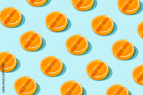 Trendy sunlight Vitamin C pattern of orange slices in the form of tablets on a light blue background. Minimal Health Concept