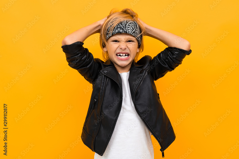 upset boy bully rips his hair, a boy in a black jacket on an orange background upset boy bully rips his hair, a boy in a black jacket on an orange background