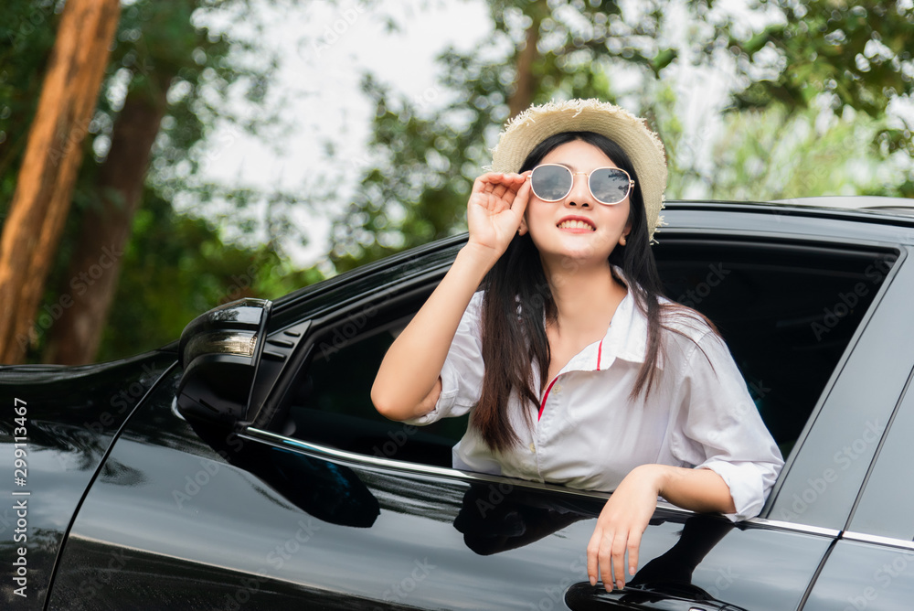 Happy beautiful girl traveling in a car across Europe with focus in front of the car Happy beautiful girl traveling in a car across Europe with focus in front of the car